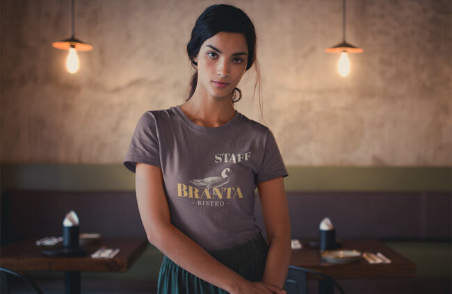 ragazza lavora in un bistro con una maglietta personalizzata con scritta staff e logo